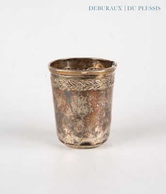 une tasse en argent posée sur une surface blanche