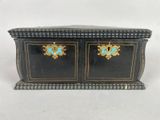 an image of a black and gold box with two blue flowers on it