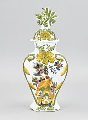 un vase blanc orné de fleurs jaunes et bleues