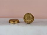 a gold coin sitting on top of a white counter next to a stack of coins