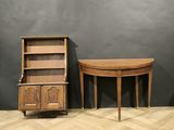 deux tables en bois et une armoire dans une pièce aux murs gris