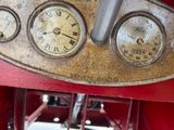 a close up of a clock on the side of a red car