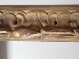 a close up of a gold frame with carvings on it
