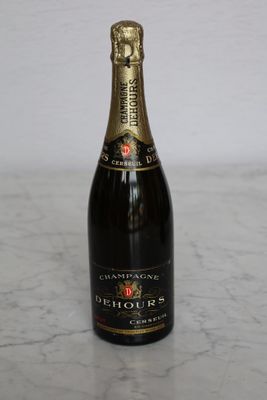 bottle of champagne sitting on a marble counter top with a white wall in the background