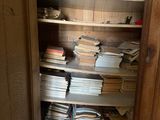 un placard rempli de livres et de papiers, dans un coin de la pièce
