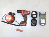 a cordless drill, a cordless charger, a cordless charger, and a cell phone on a table