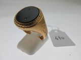 l'image d'une bague en or ornée d'une pierre noire
