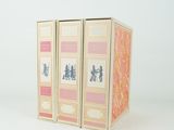 trois livres sont empilés sur une surface blanche