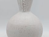 a white vase that has a light on top of it