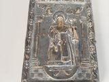 an old silver box with a picture of a man and a woman on it