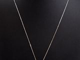un collier avec un pendentif en forme de croix autour du cou d'un mannequin