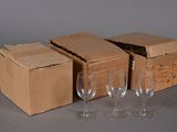 three empty wine glasses and a cardboard box on a table