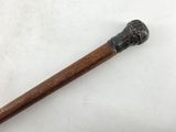 a close up of an old walking stick on a white surface