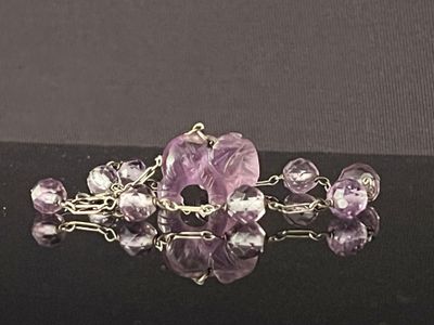 purple amethorate and amethorate beaded broochle on a black surface