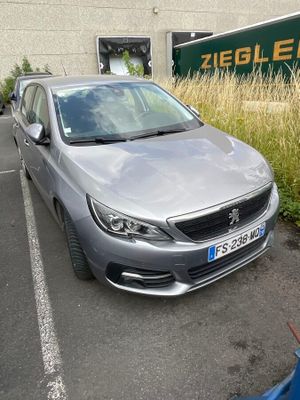 a silver car parked in a parking lot next to a building