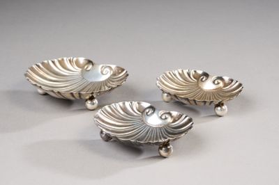 trois couverts posés sur une surface blanche avec un fond gris