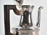 a silver tea pot with a wooden handle on a stand