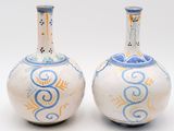 two vases with designs on them on a white surface