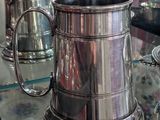 deux tasses en argent posées sur une table en verre
