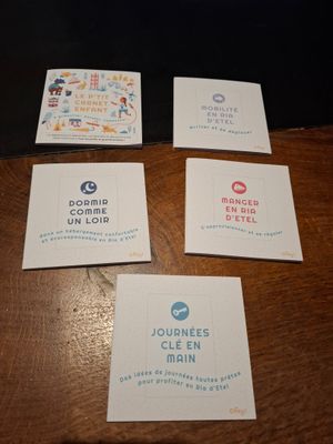 four business cards on a wooden table with a black background