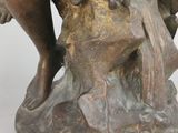 bronze statue of a woman with a bird on her shoulder