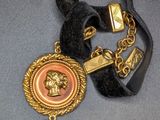 a necklace that has a picture of a woman with a pearl on it