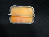 a picture of a yellow and orange broochle on a black background