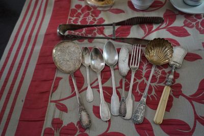 une table sur laquelle sont posés des couverts et recouverte d'une nappe rouge et blanche