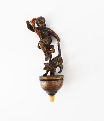 une statue représentant un homme avec un chat, accrochée à un mur