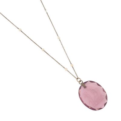 un collier avec une pierre rose suspendue à une chaîne