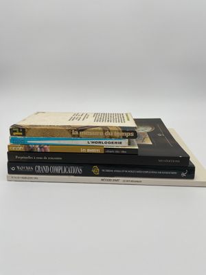 trois livres empilés sur une surface blanche