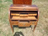 un petit bureau en bois muni de tiroirs, posé dans l'herbe