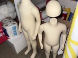 deux mannequins debout l'un à côté de l'autre dans une pièce