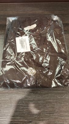 une chemise marron emballée dans du plastique, posée sur une table