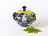une petite décoration en verre avec une feuille posée par terre