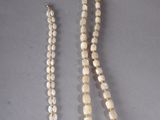 a white beaded necklace with a silver clasp and a white beaded necklace with a silver clasp