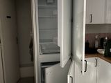 un réfrigérateur ouvert dans une cuisine au sol carrelé