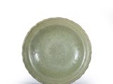 a green bowl sitting on top of a white table