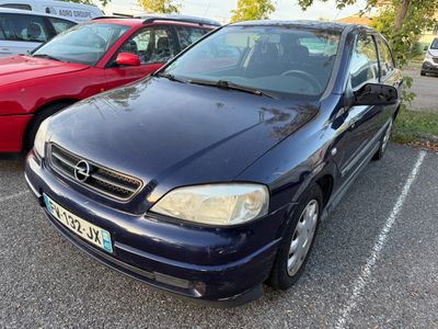 a blue car parked in a parking lot with other cars in the background