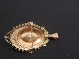 an image of a gold plated broochet on a black surface