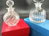 deux flacons de parfum posés sur une boîte bleue