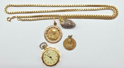 un collier en or et une montre de poche en or posés sur une surface blanche