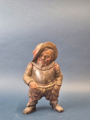 une petite figurine représentant un garçon coiffé d'un chapeau