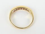 a close up of a gold ring with ruby stones