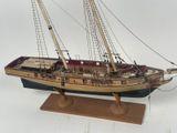 a model of a sailboat on a wooden stand