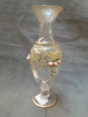 un vase en verre orné de fleurs, posé sur une table