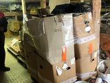 un homme debout à côté d'une pile de cartons dans un entrepôt