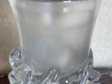un verre posé sur une table, à côté d'un vase
