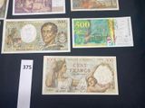 several different bank notes are displayed on a table with a price tag