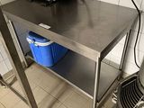 une table en acier inoxydable sur laquelle se trouve un seau bleu